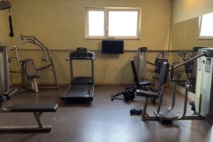Fitnessraum des Ringhotel Winzerhof mit veralteten Trainingsgeräten und Laufband