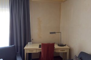 Hotelzimmer mit Schreibtisch und fleckiger Wand im Ringhotel Winzerhof