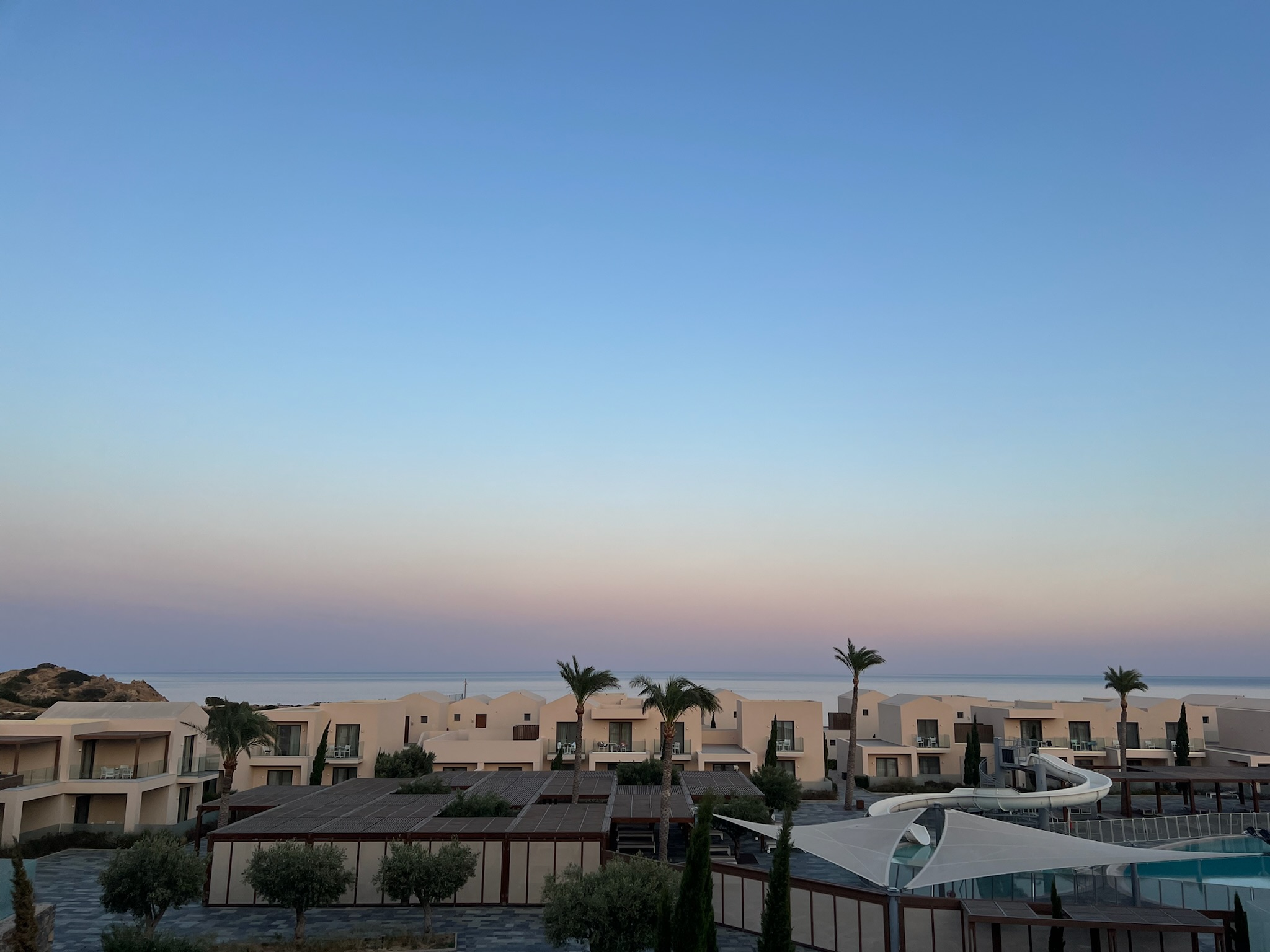 Blick auf die Zimmergebäude und den Pool mit Rutsche im ROBINSON Ierapetra.